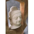 Budda - Rzeźbiona kamienna głowa Buddy otoczona drewnem tekowym